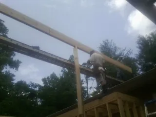 Carpenter setting a ridge beam over a new addition frame — Ice Dam Removal by Roofing Brothers in Middlefield