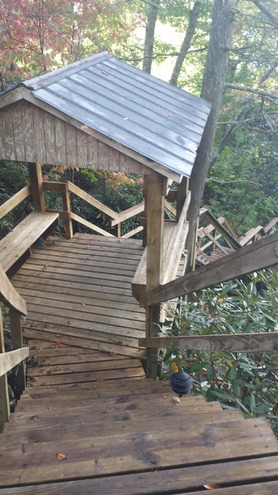 Metal roofed shelter over wooden steps on a wooded walkway — Skylight Repair & Installation work by our crew in Middlefield